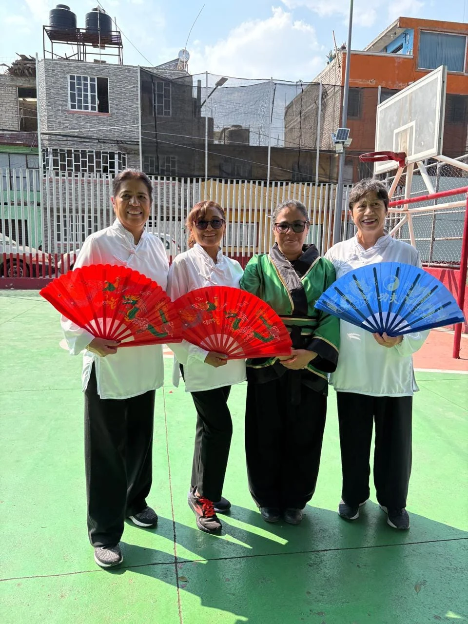 Cuatro practicantes con abanicos de colores